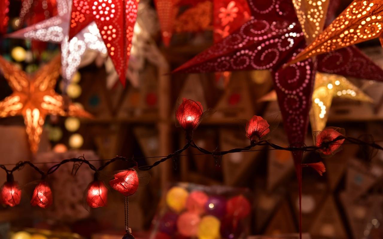 Sterne und Lichterketten leuchten auf einem Weihnachtsmarkt