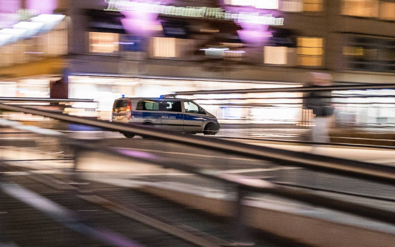 Ein Polizeiauto fährt nachts schnell durch die Stadt.