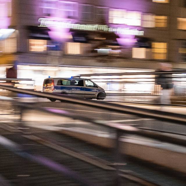 Ein Polizeiauto fährt nachts schnell durch die Stadt.