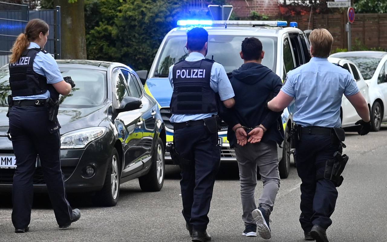 Der mutmaßliche Täter wird von der Polizei in Handschellen abgeführt.