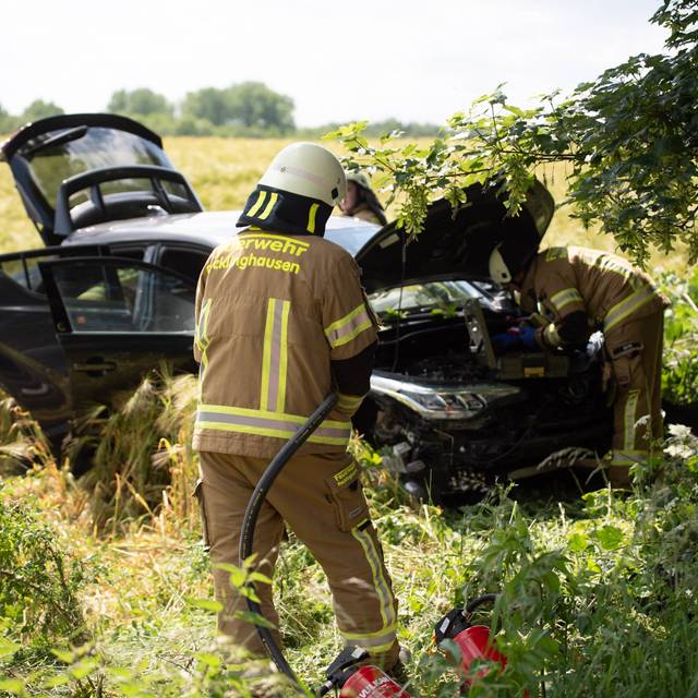 Das Auto stand nach dem Unfall auf der B225 komplett schrott im Feld. Feuerwehrmänner kümmerten sich darum.