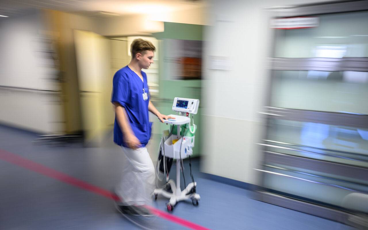 Ein Krankenhaus-Mitarbeiter beziehungsweise Pfleger ist im Krankenhaus zu sehen.