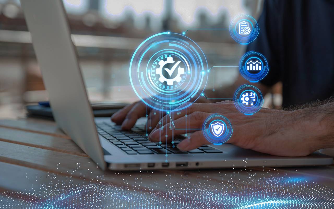 Hände am Laptop mit Datenschutz Symbol.