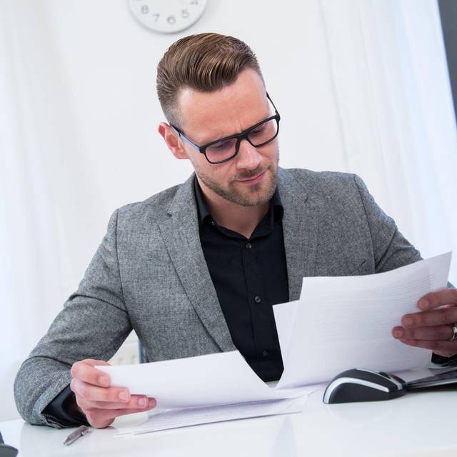 Ein Mann sieht im Büro in Unterlagen