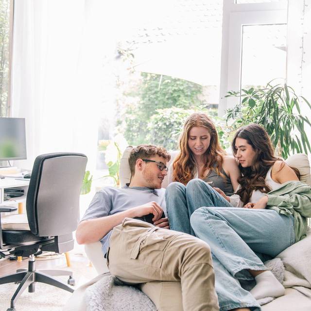 Jugendliche blicken gemeinsam auf ein Smartphone