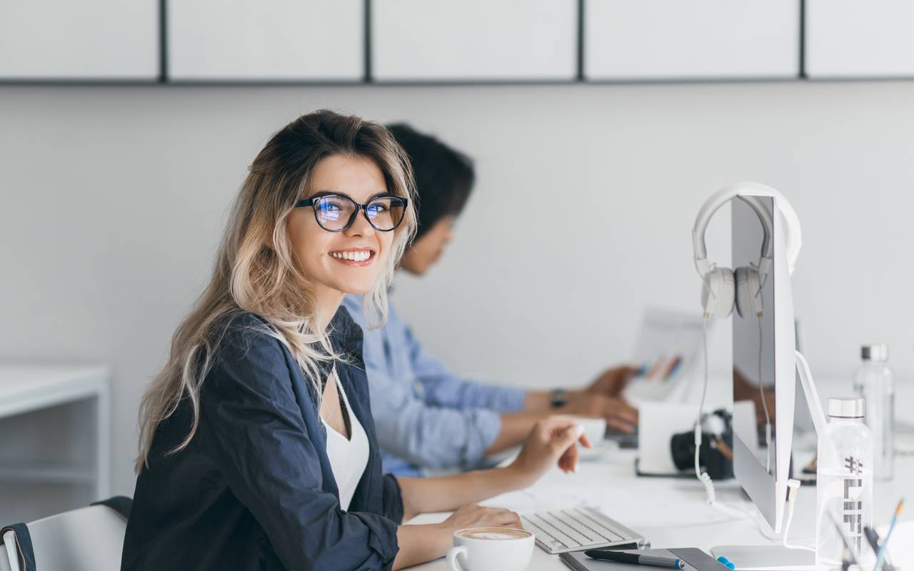 Frau sitzt im Büro am Computer.