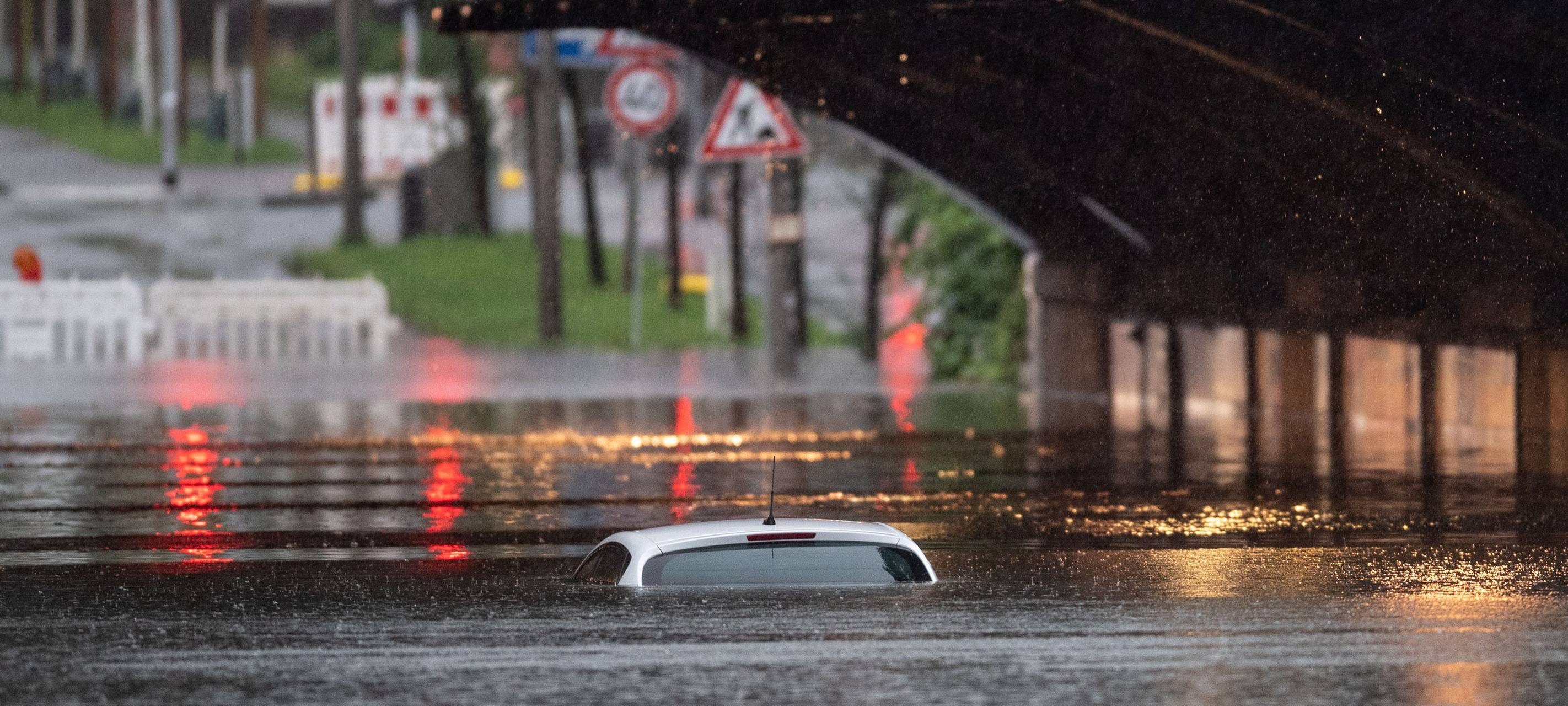 Ein Auto versinkt in den Wassermassen.