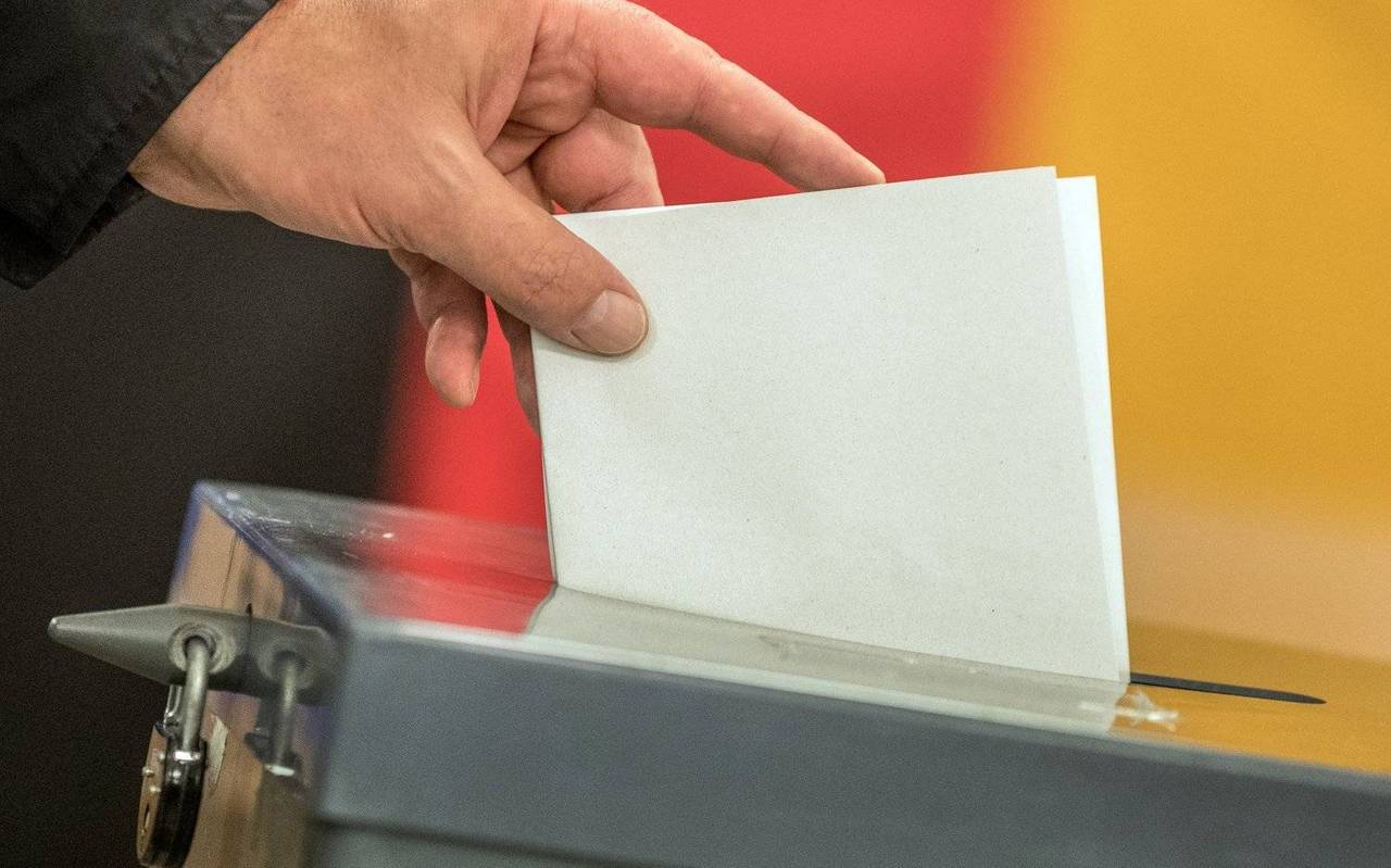 Wahlurne mit Deutschlandflagge im Hintergrund