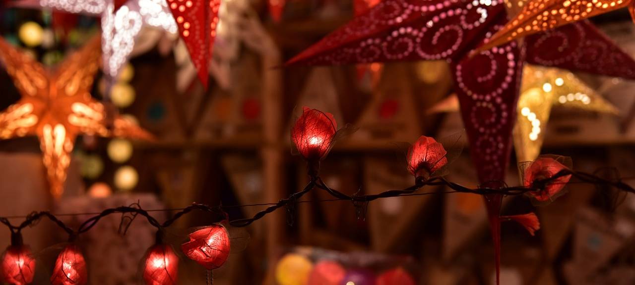 Sterne und Lichterketten leuchten auf einem Weihnachtsmarkt