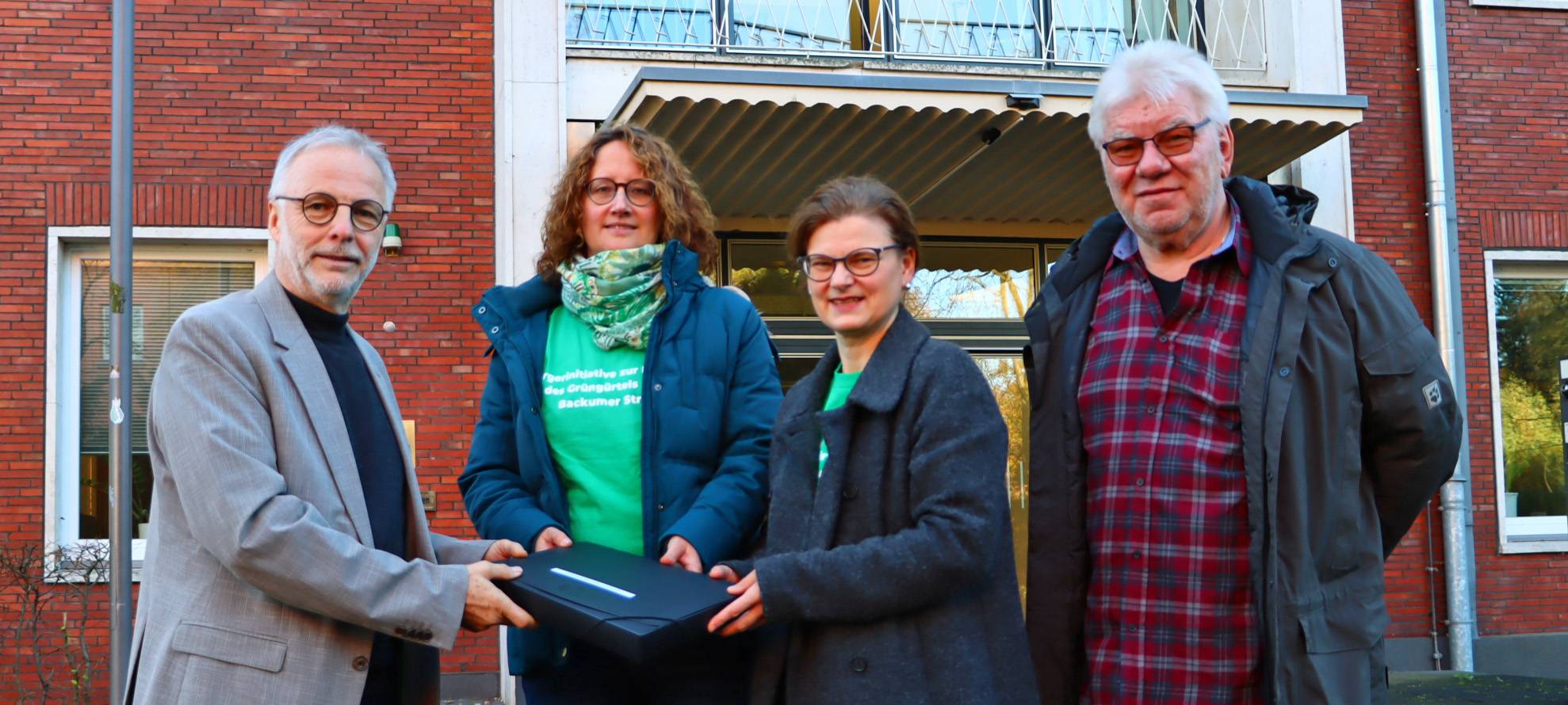 Mitglieder der "Bürgerinitiative zur Erhaltung des Grünzugs an der Backumer Straße" übergeben die Unterschriftensammlung im Hertener Rathaus