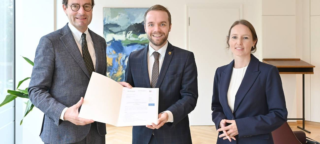 Regierungspräsident Andreas Bothe, Bürgermeister der Stadt Waltrop Marcel Mittelbach und Jeanette Sebrantke, Dezernentin für Stadtentwicklung, Umwelt und Bauen bei der Bescheidübergabe in Münster.
