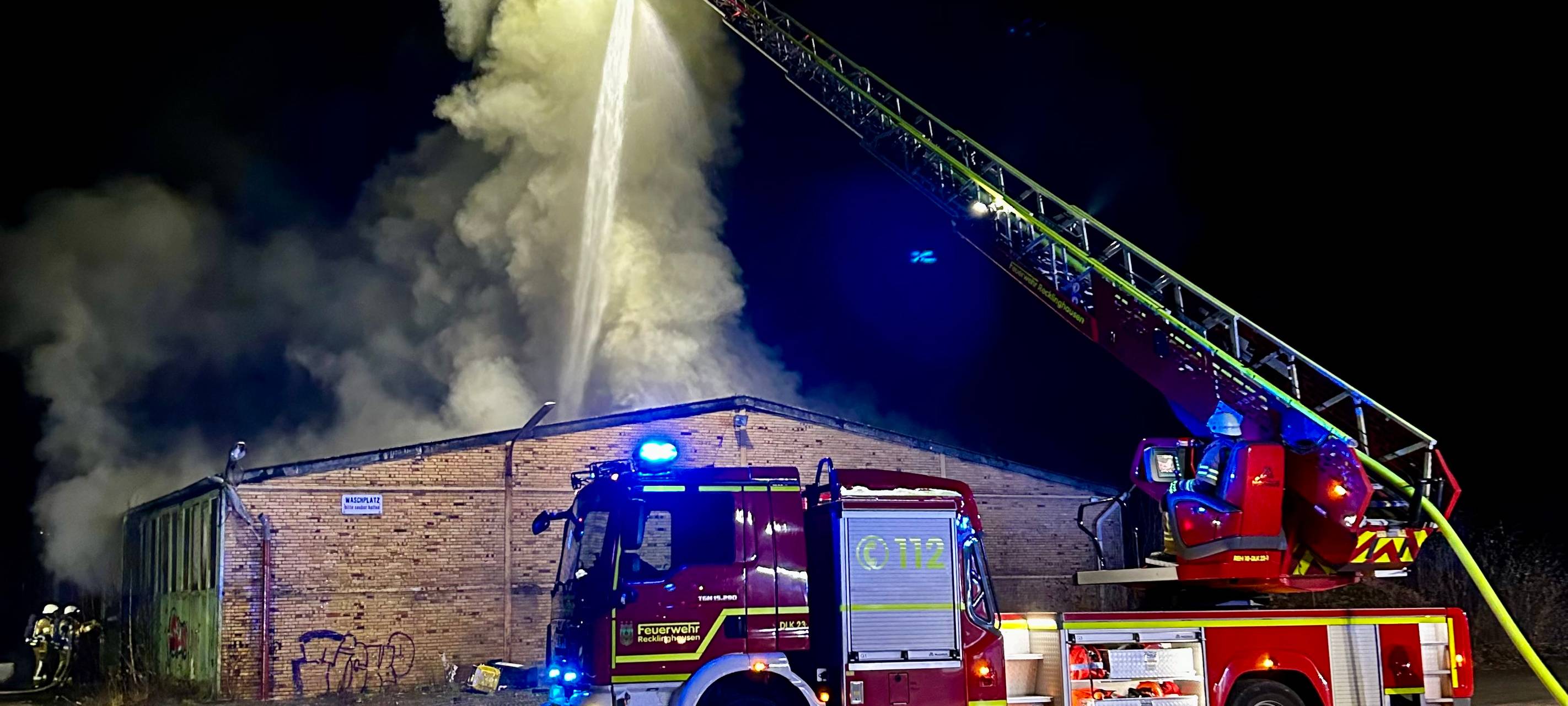 Von einer Drehleiter aus löschte die Feuerwehr den Lagerhallen-Brand in Recklinghausen.