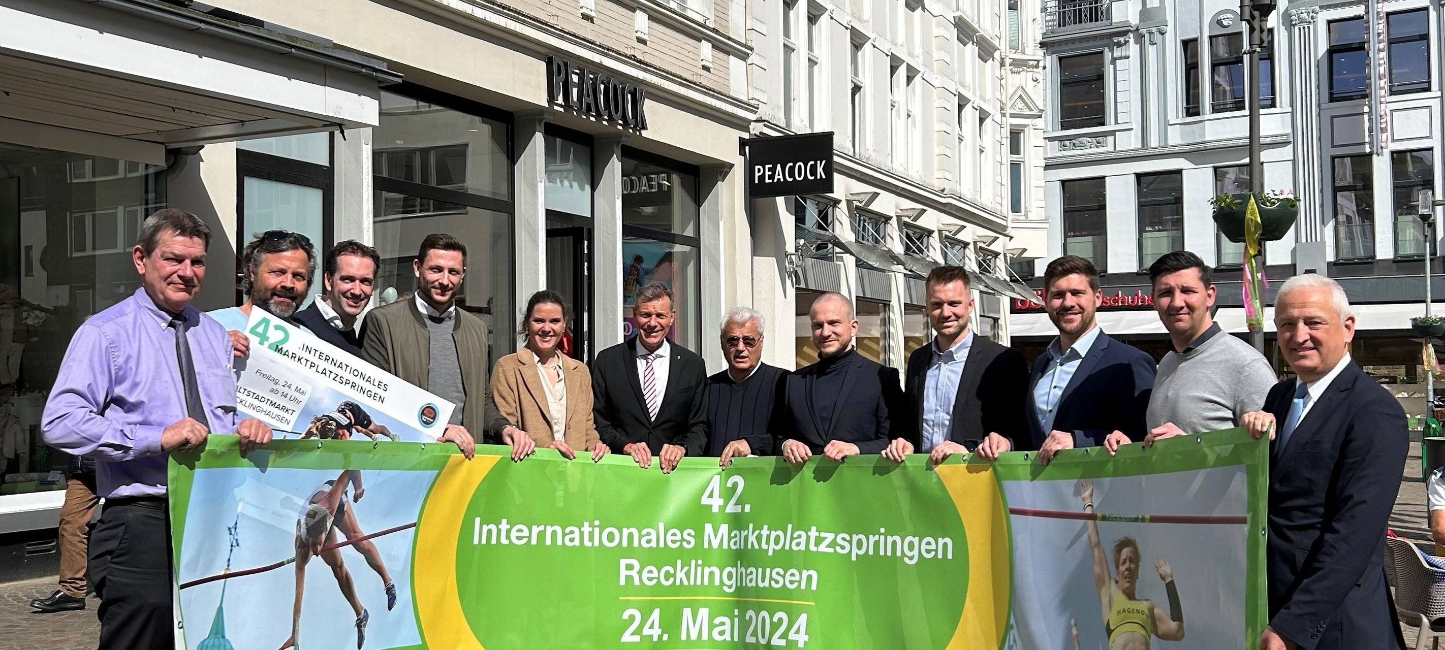 Recklinghausens Bürgermeister Christoph Tesche und Sponsoren präsentieren das Plakat zum Marktplatzspringen 2024.
