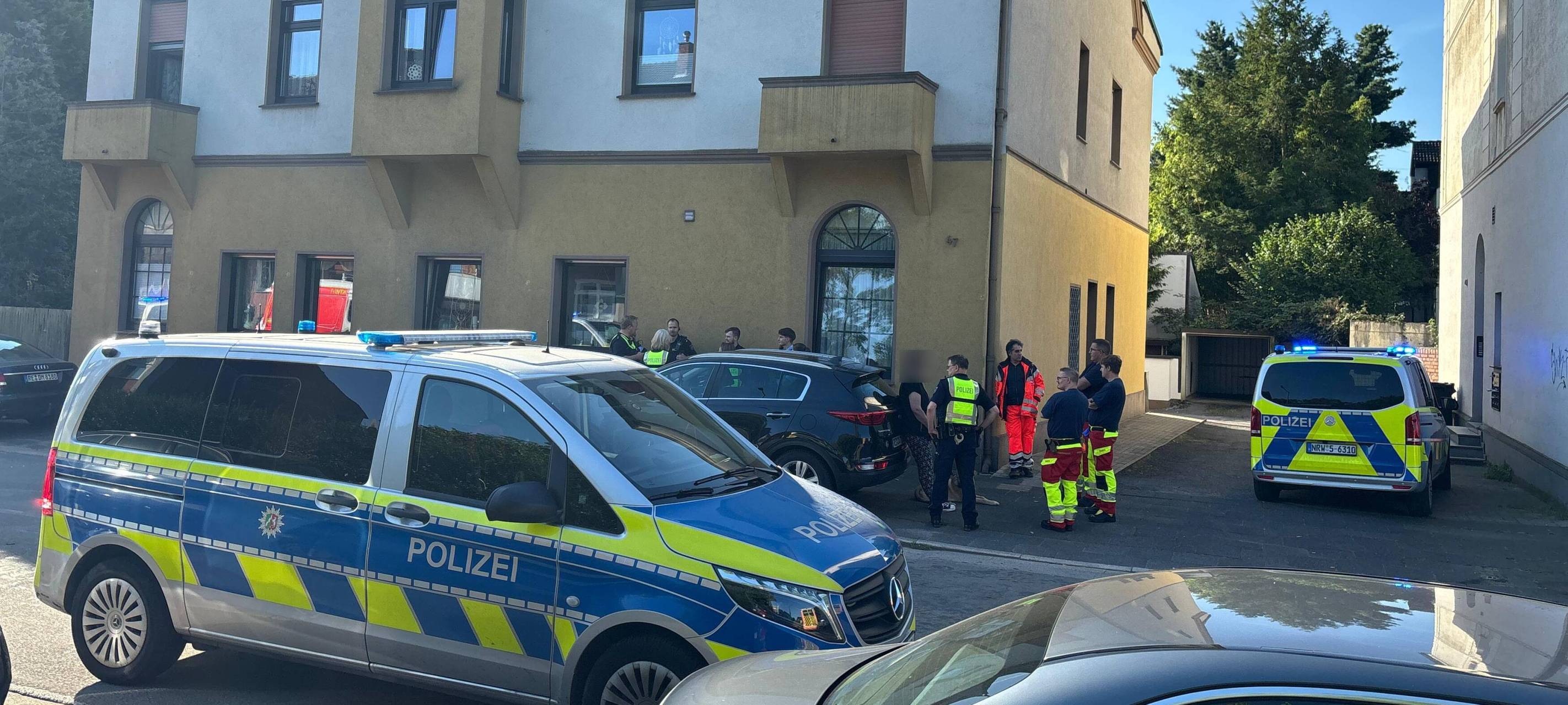 Mehrere Einsatzkräfte von Polizei und Rettungsdienst stehen vor einem Haus in Recklinghausen-Grullbad.