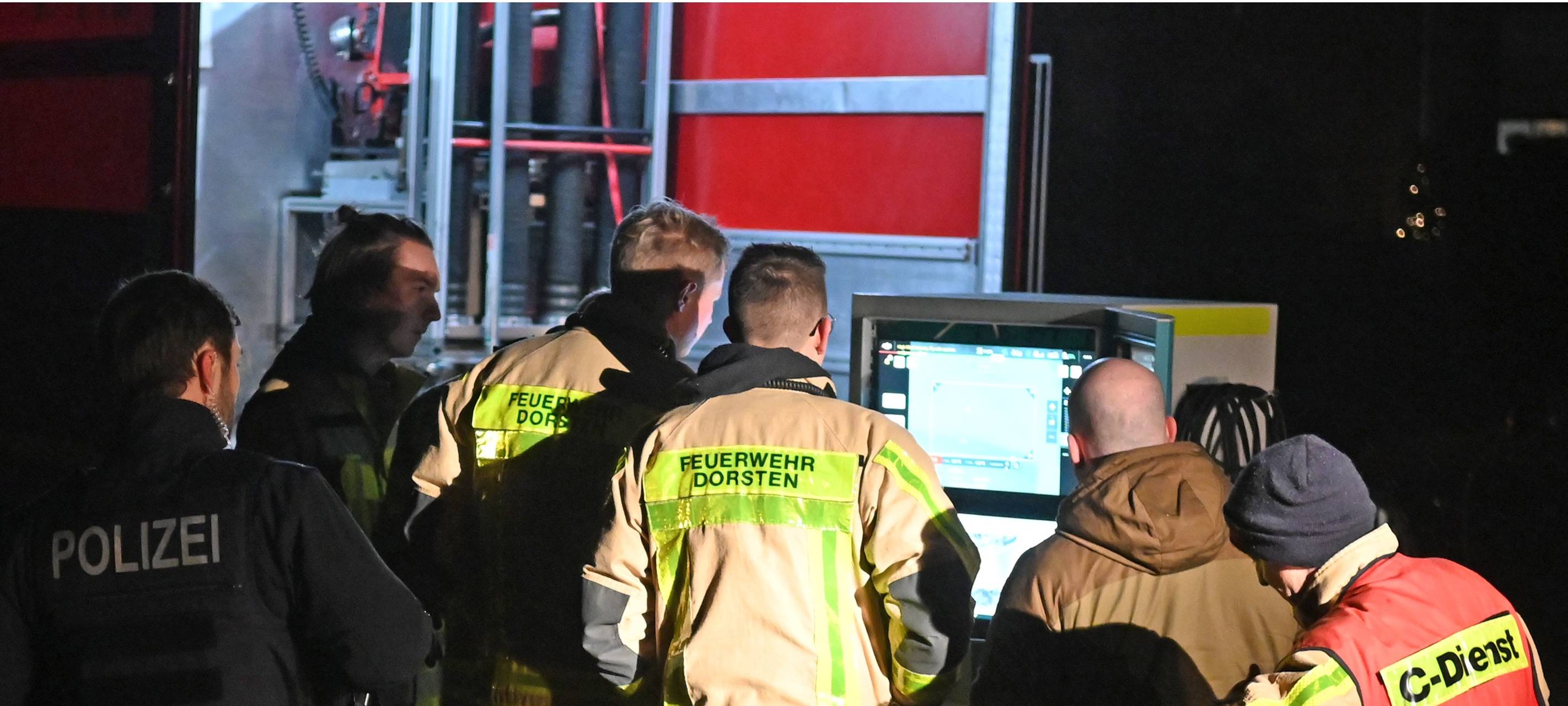 Einsatzkräfte schauen sich die Bilder einer eingesetzten Drohne bei der Suche nach dem vermissten Kind in Dorsten an.