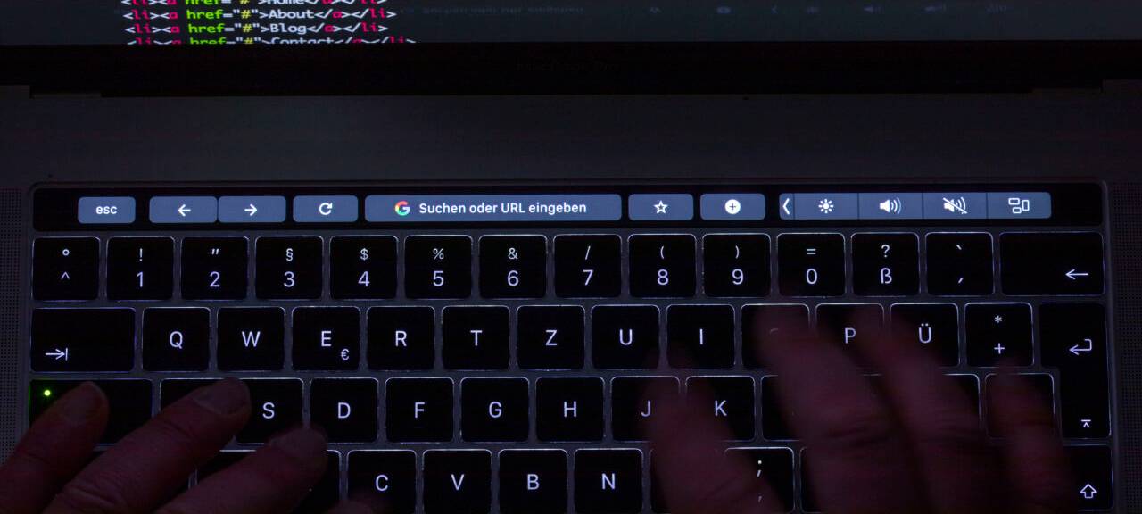 Der html-Code für die Programmierung einer Internetseite ist auf dem Monitor eines Laptops zu sehen