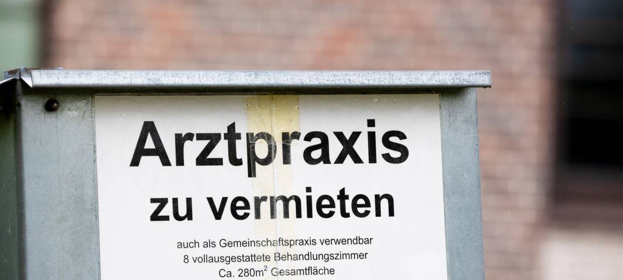 Ein Schild mit der Aufschrift «Arztpraxis zu vermieten» steht vor einem Gebäude.