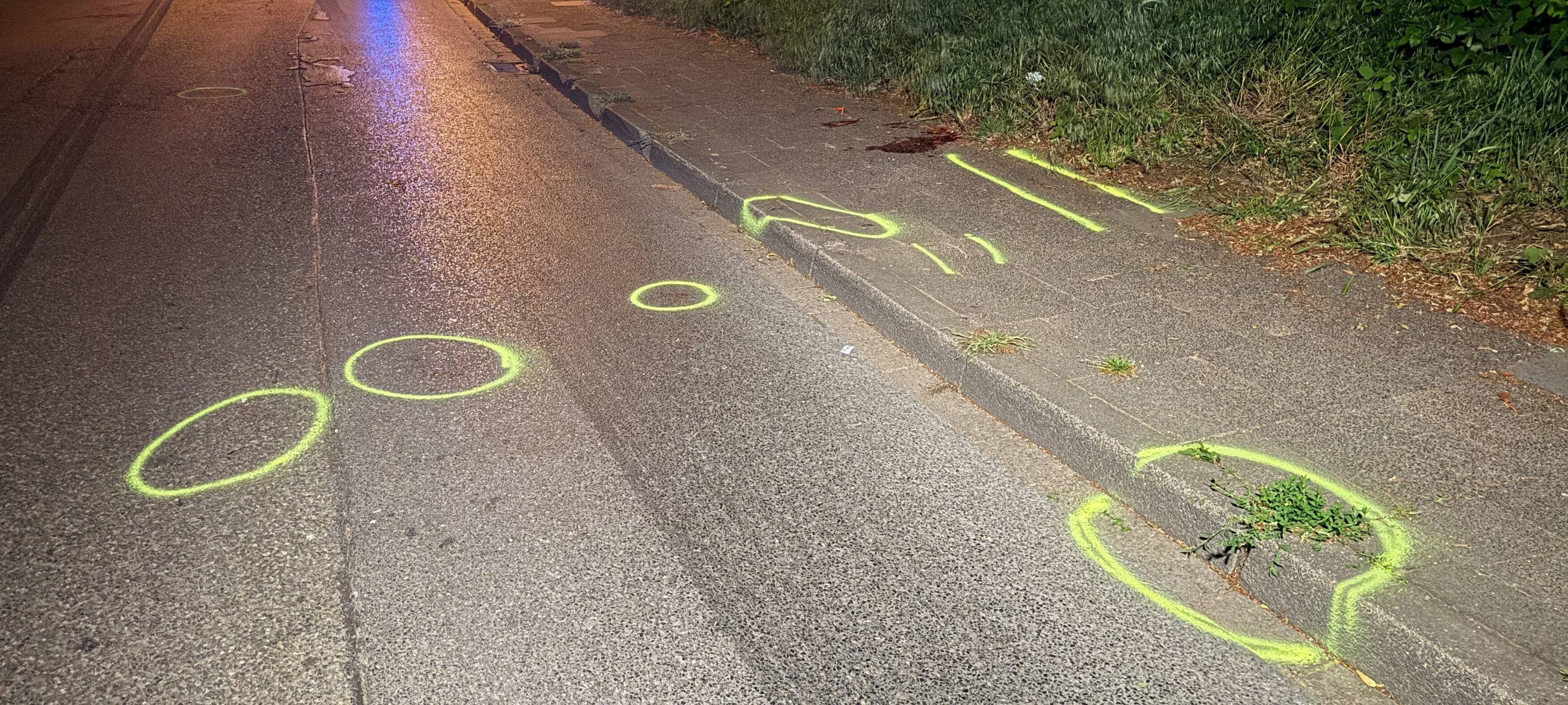 Auf dem Bürgersteig in Marl sind Markierungen der Polizei und ein großer Blutfleck nach dem Fahrradunfall zu sehen.