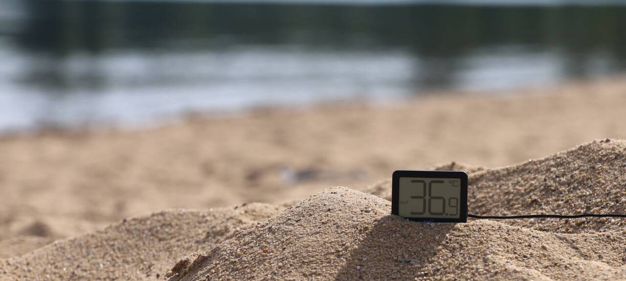 Ein Thermometer zeigt an einem Badestrand knapp 37 Grad an.