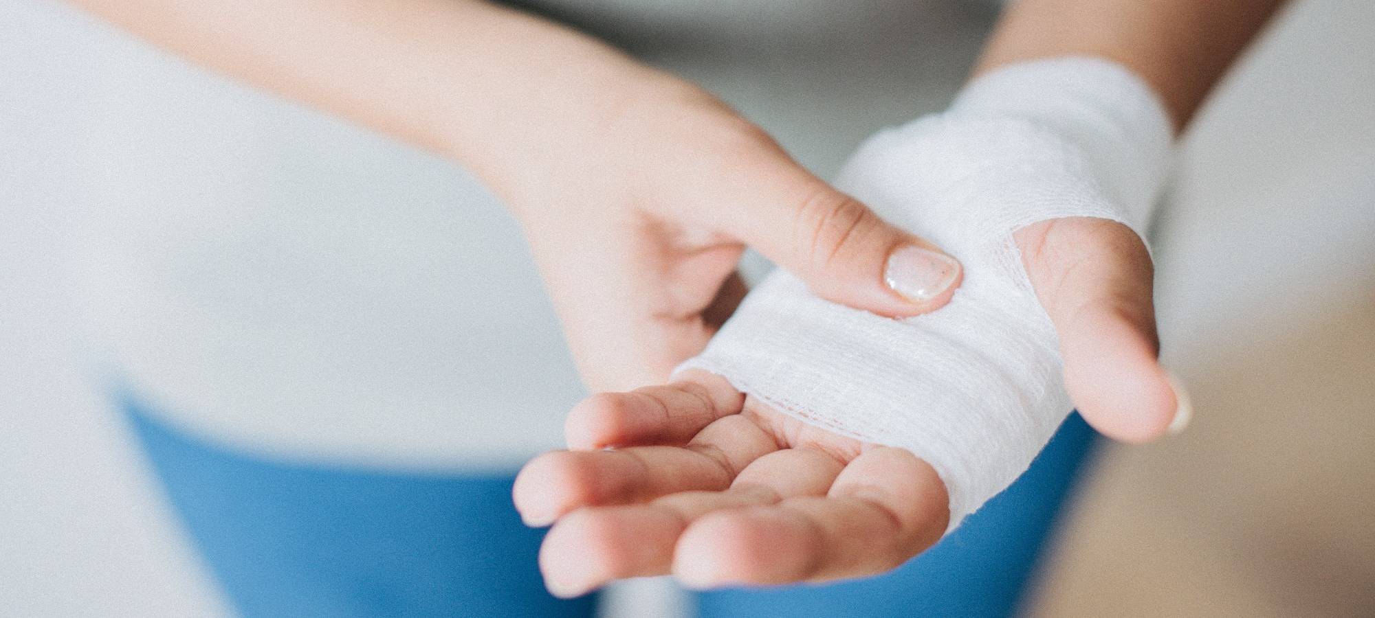 Frau trägt Verband an der Hand