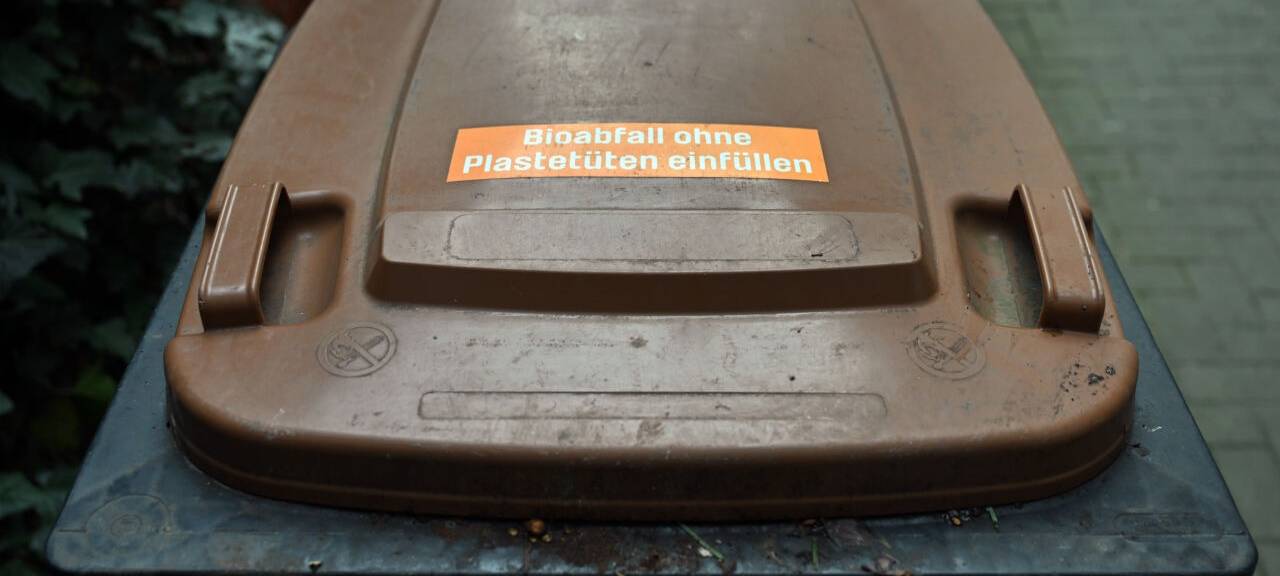 Eine Biotonne steht vor einem Wohnhaus. Vor allem in den größeren Städten Thüringens gehört die Biotonne schon länger zum Stadtbild. Doch es gibt auch Kommunen im Freistaat, die auf andere Entsorgungsmodelle setzen. Dem Landesamt für Umwelt, Bergbau und Naturschutz zufolge stieg die über die Biotonne entsorgte Abfallmenge in Thüringen auf rund 83.000 Tonnen im Jahr 2021 an.