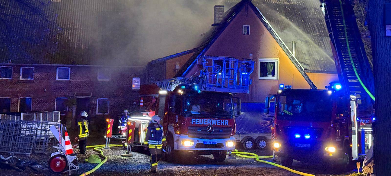 Aus einem Dachstuhl kommt Rauch, die Feuerwehr löscht den Brand von einer Drehleiter.