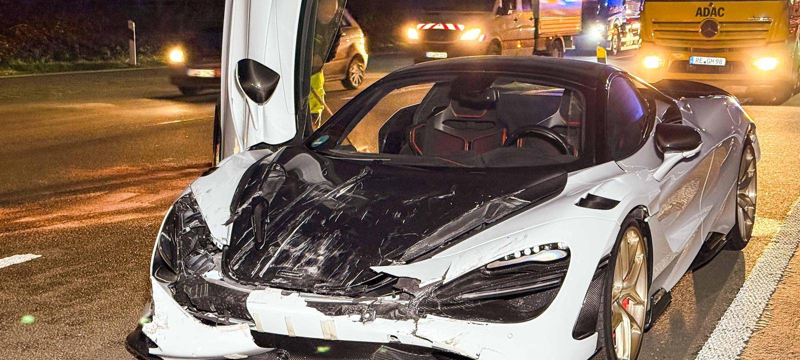 Ein teurer Sportwagen steht zerstört mit nach oben geöffneter Beifahrertür auf der Autobahn