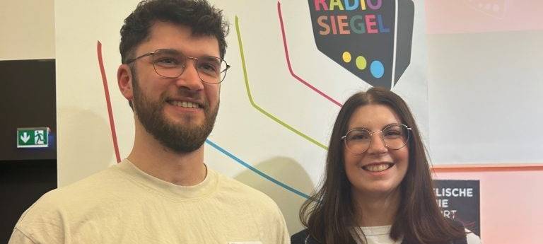 Jan Schmitz, Volontär bei Radio Vest, und Joaquina Raulin, Volontärin beim Dortmunder Sender Radio 91.2, erhalten das Radiosiegel für ihre Ausbildersender.