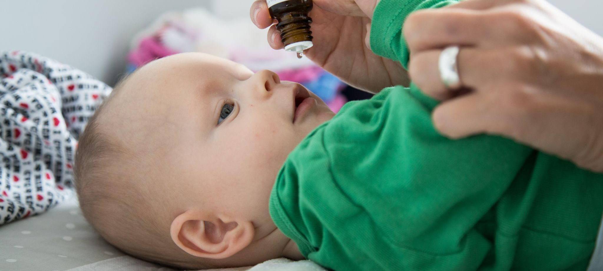 Eine Mutter verabreicht ihrem Baby Vitamin-D-Tropfen