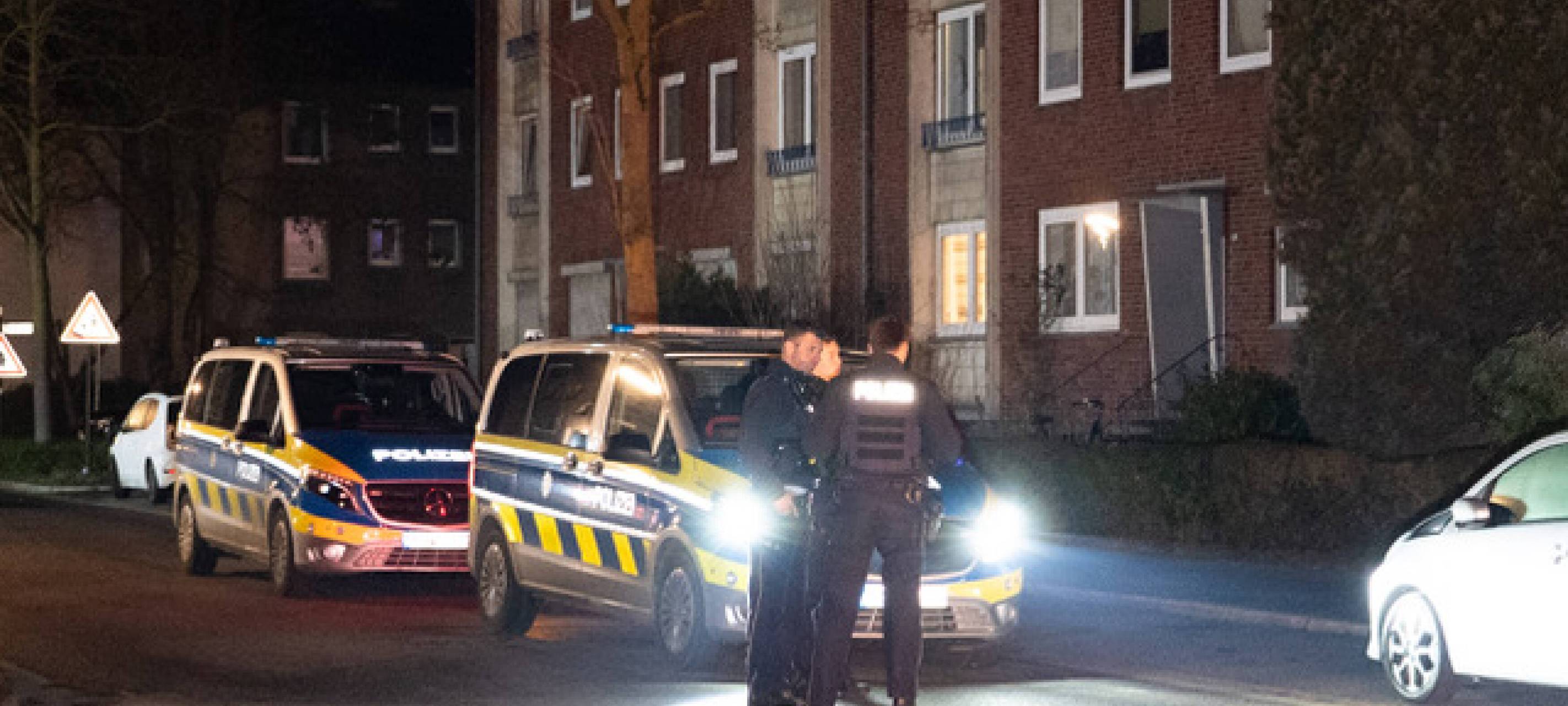 Zwei Polizeiautos und mehrere Polizisten stehen vor dem Tatort in Recklinghausen