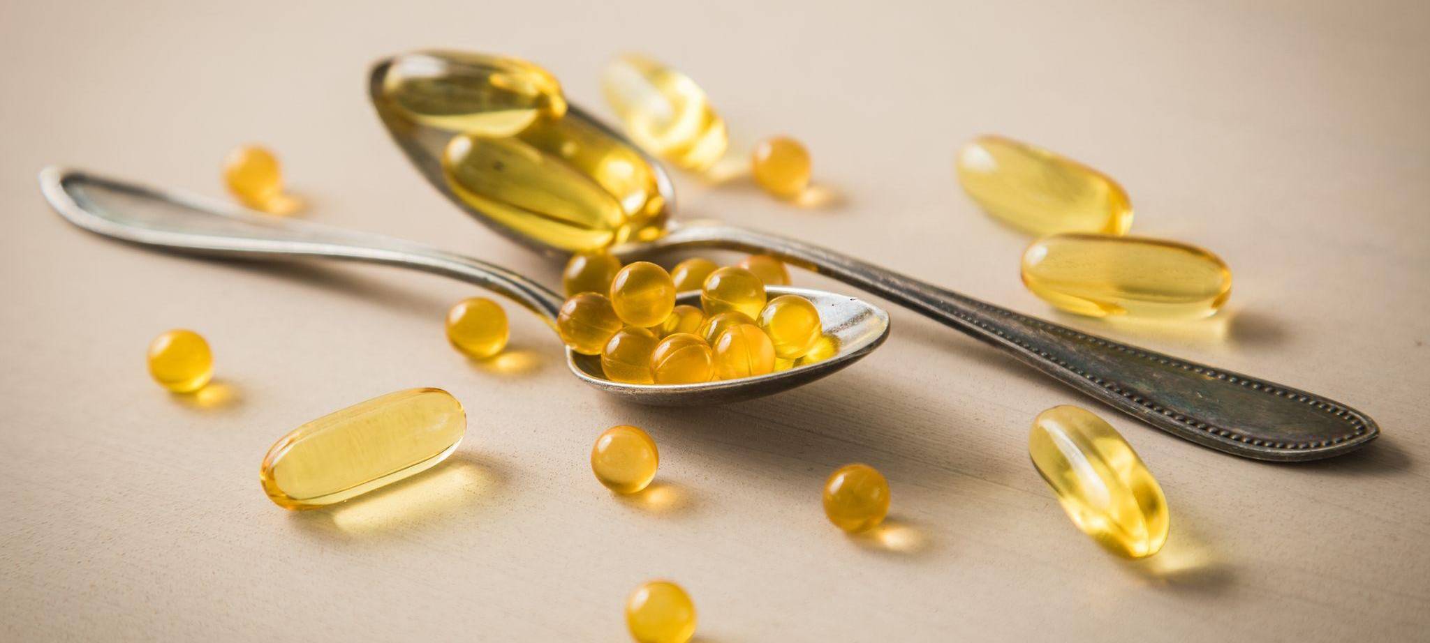 Tabletten und Kapseln liegen auf Löffeln