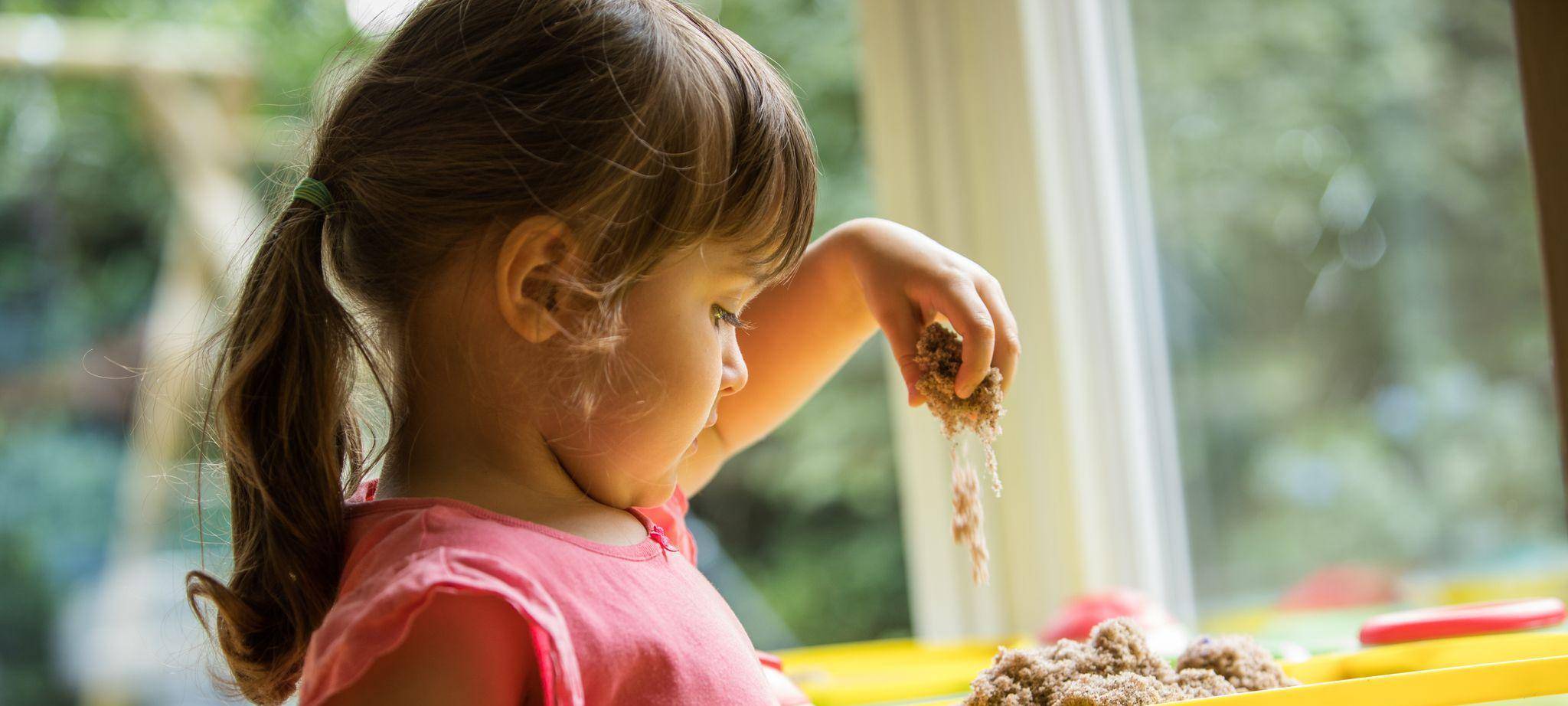 Ein Mädchen soielt mit Knetsand