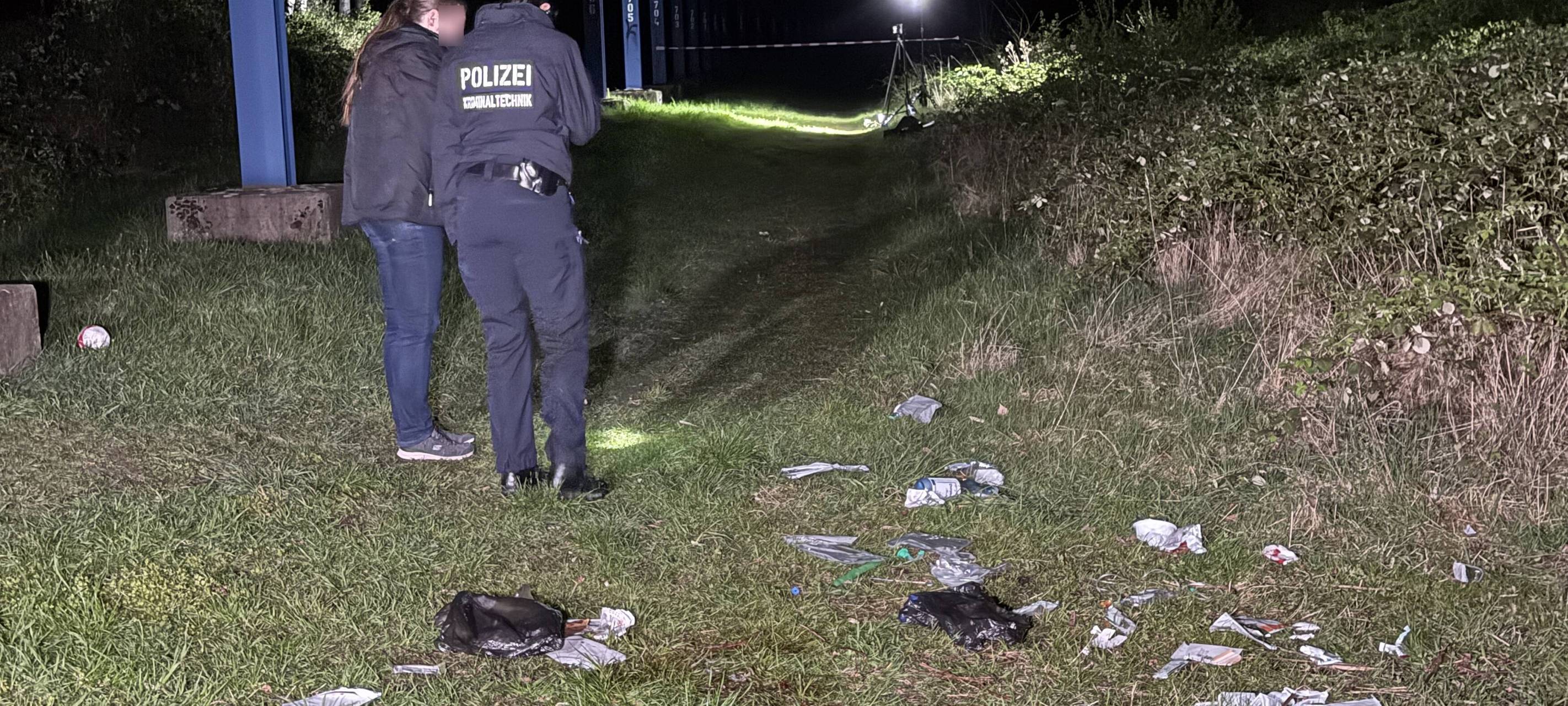 Polizisten stehen vor auf dem Boden verstreuten Beweismitteln in Gladbeck