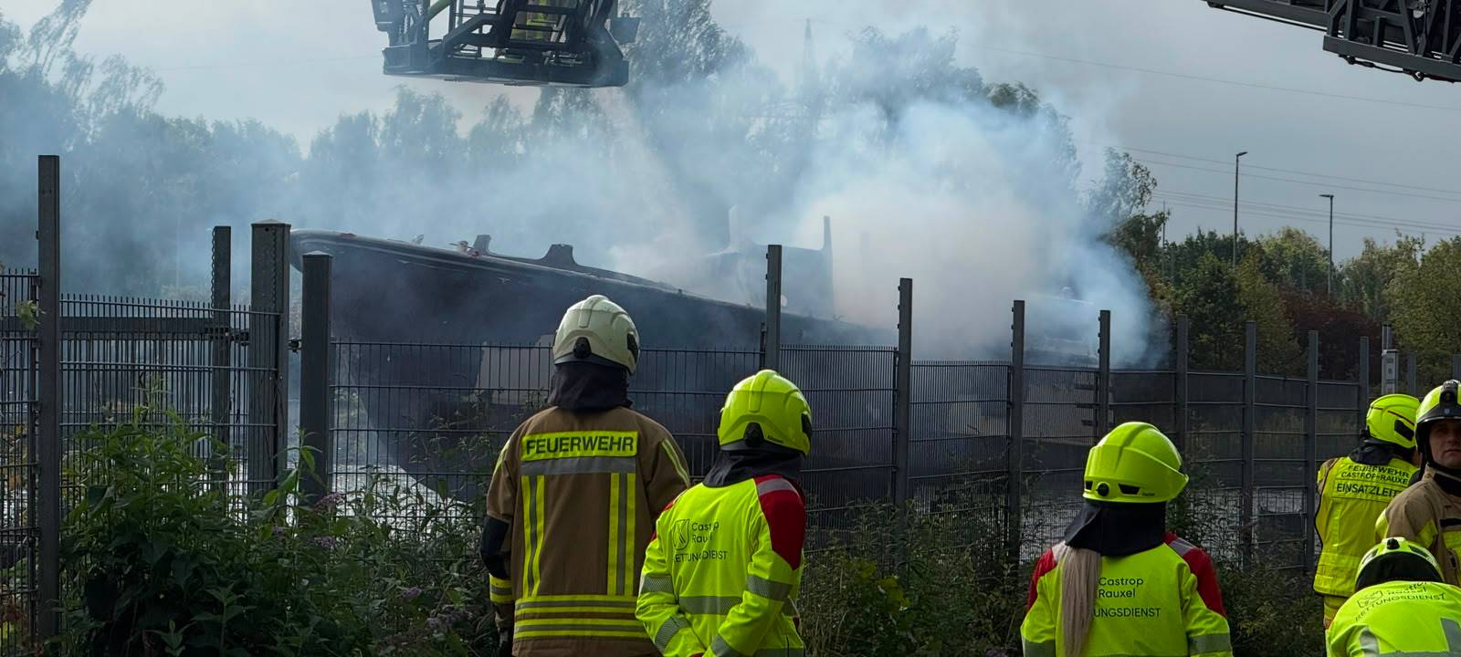 Mit Hilfe einer Drehleiter versucht die Feuerwehr, das brennende Schiff in Castrop-Rauxel zu löschen.