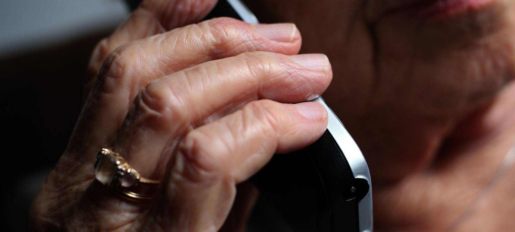 Seniorin telefoniert mit einem Festnetztelefon