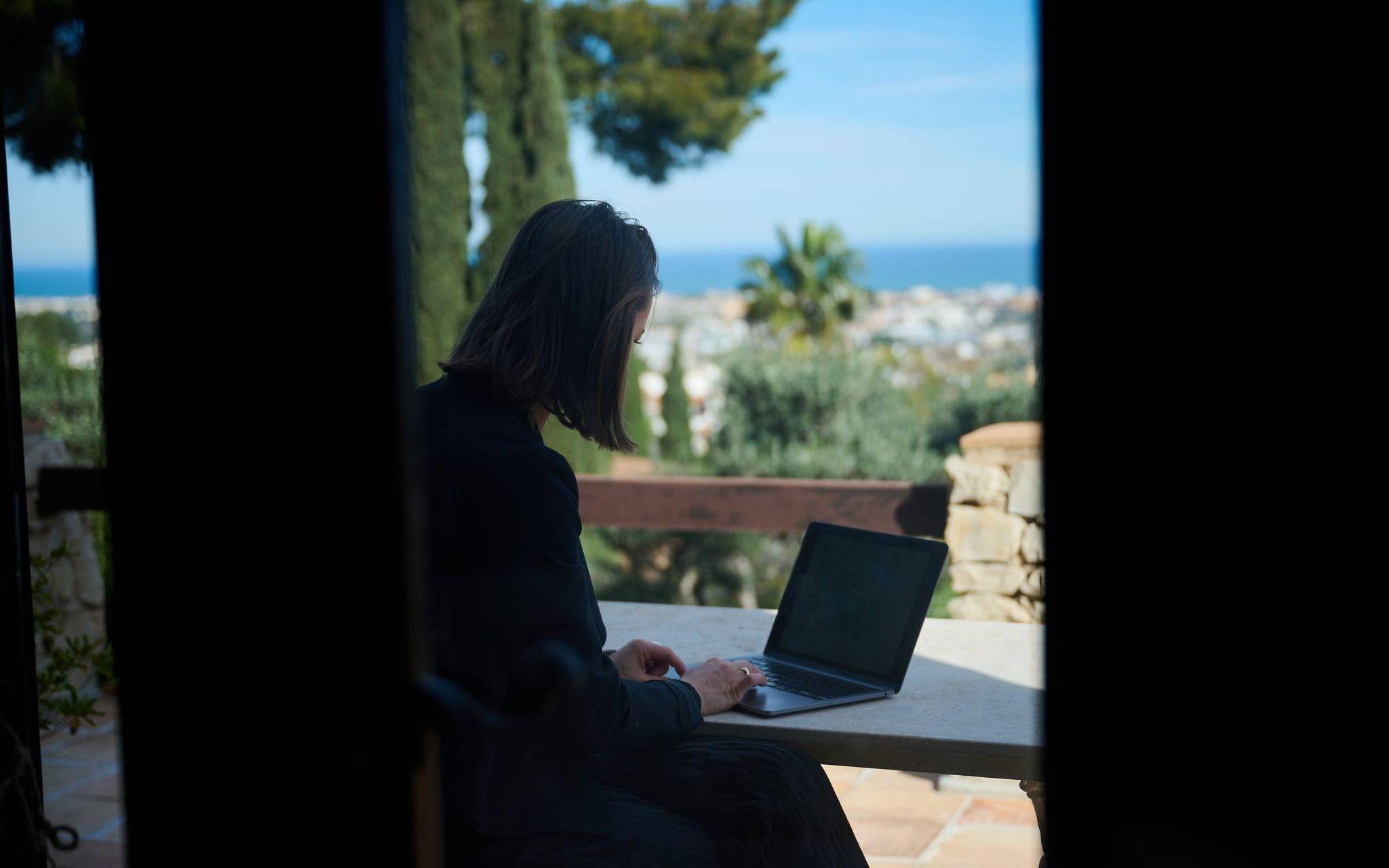 Frau arbeitet im Homeoffice an einem Computer an der Costa Blanca