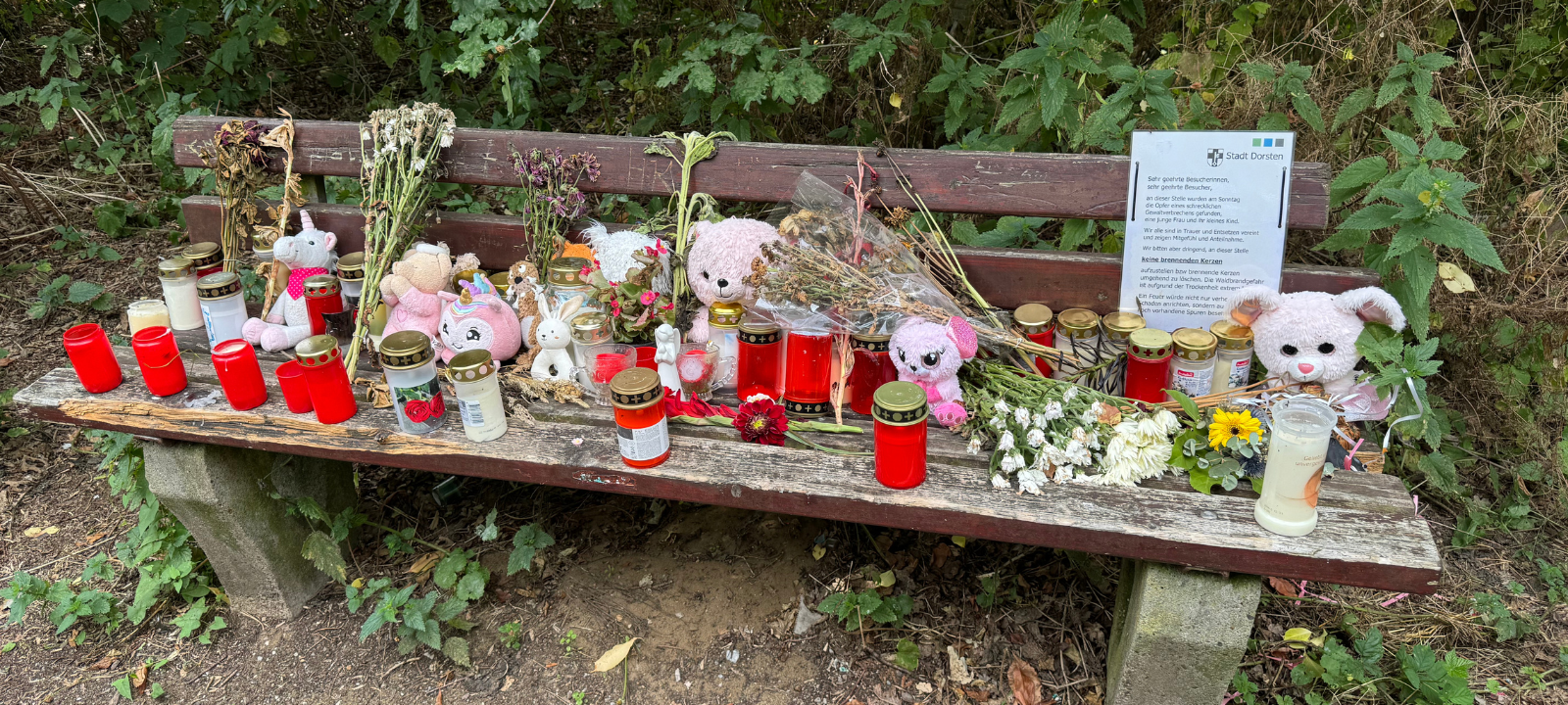 Auf einer Bank am Tatort in Dorsten sind unzählige Kerzen und Kuscheltiere aufgestellt worden.