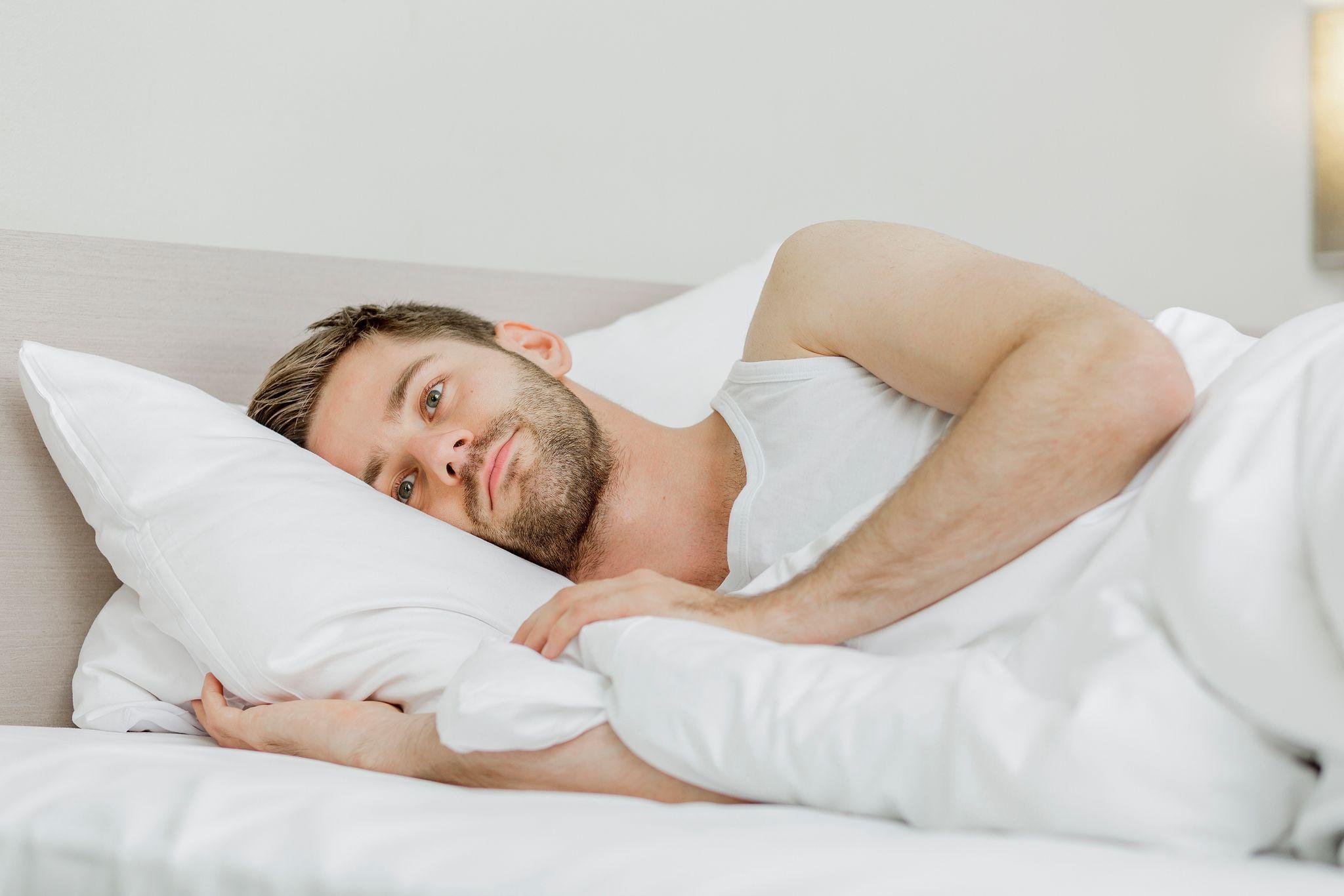 Mann liegt wach in seinem Bett