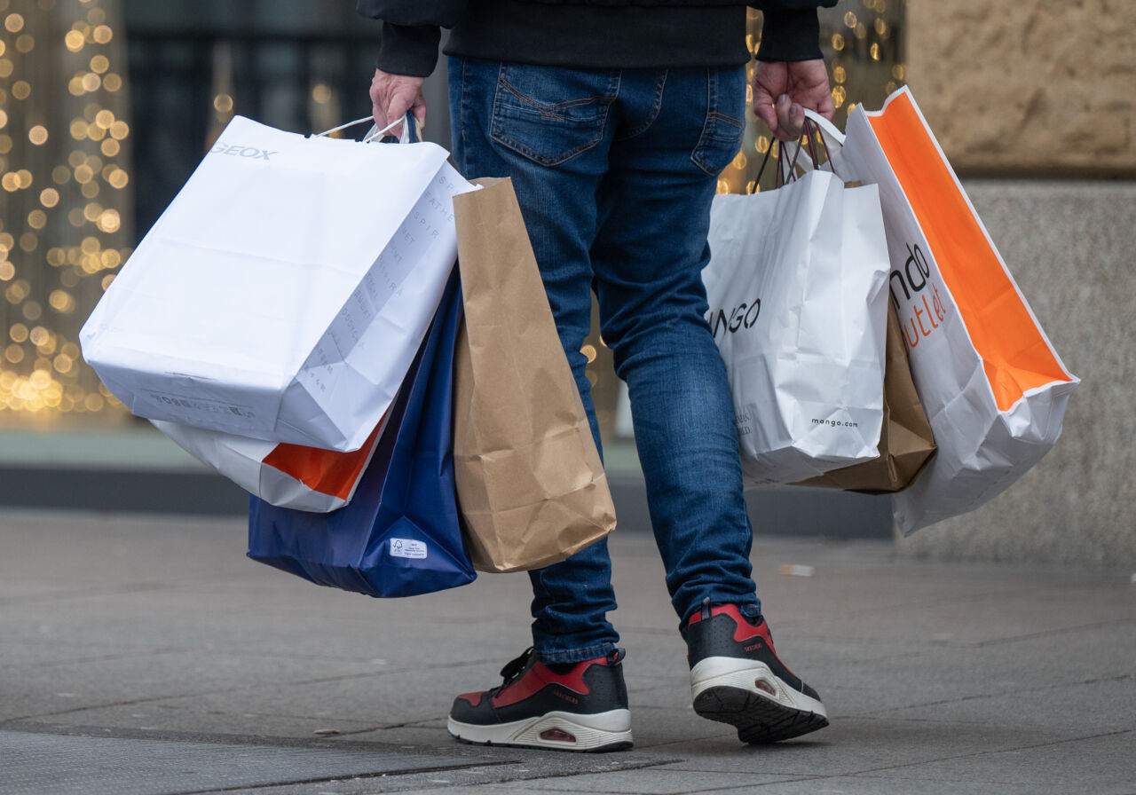 Ein Mann trägt viele Einkaufstaschen nach einer Shoppingtour