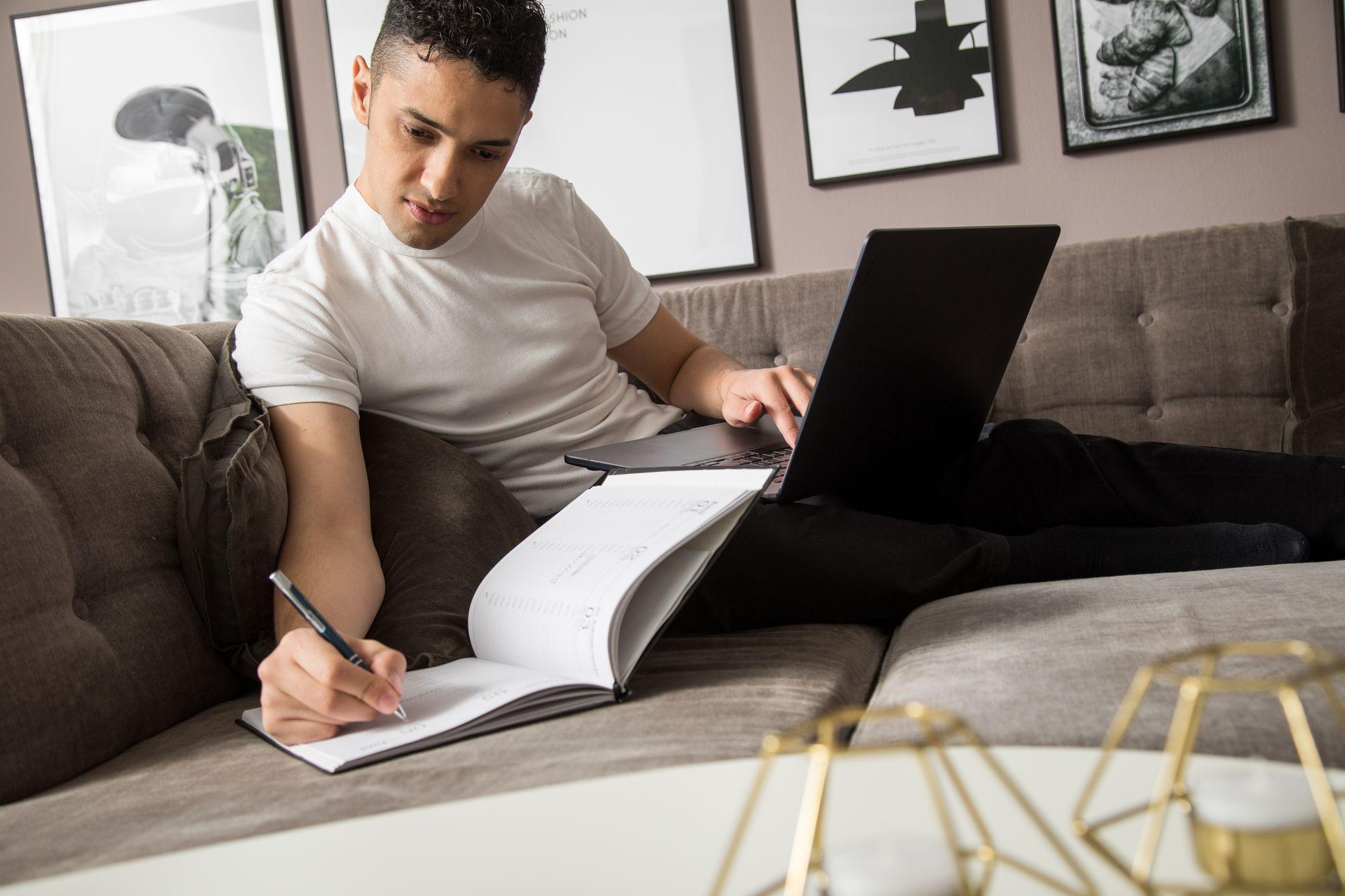 Mann arbeitet mit Kalender und Laptop